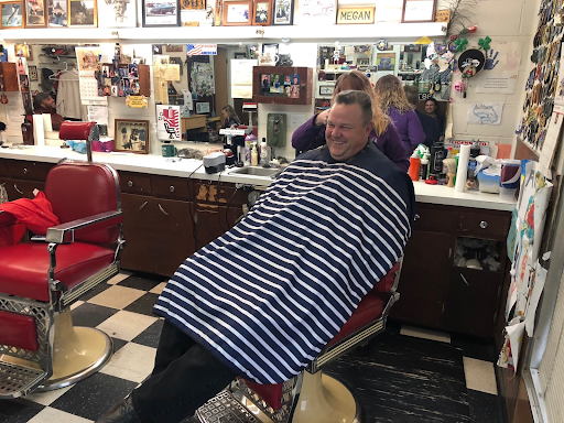 Jon Tester in a chair at a hair salon getting his hair cut