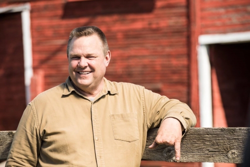 Jon Tester leaning on a fence post JPEG.